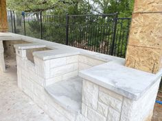 an outdoor stone bar is being built on the side of a fenced in area