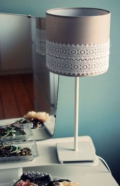 a lamp that is sitting on top of a table next to other items in front of a mirror