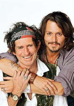 two men are posing for the camera with their arms around each other and one is wearing a bandana