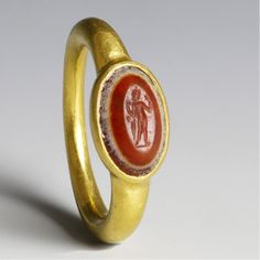 This strong ring is based on a Roman example from the first century AD, and features an oval Carnelian cabochon stone held within a beautiful bezel setting. The natural fiery red Carnelian was one of the most popular stones used in Roman jewelry. Please note that there may be slight variations in the color of the Carnelian, due to the fact that each stone is unique. "Imperium" means "power." Ring Details Stone size: 8 x 10 mm (width x length) Diameter of shank: 3 mm in front, tapering to 1.8 mm Ancient Roman Jewelry, Antique Gold Rings, Roman Jewelry, Ancient Jewellery, Power Ring, Jewelry Catalog, Gold And Silver Rings, Coin Ring, Ring Antique