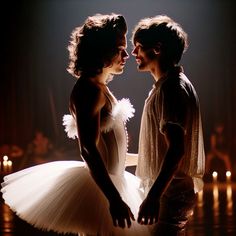 two ballerinas in white tutus standing next to each other with candles behind them