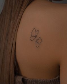 a woman with a butterfly tattoo on her back shoulder