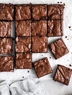 chocolate brownies cut into squares on top of a white table with a striped towel