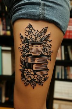 a woman with a tattoo on her leg holding a stack of books and flowers in the shape of a cup