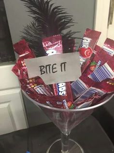 a wine glass filled with candy bar wrappers and a sign that says bye it