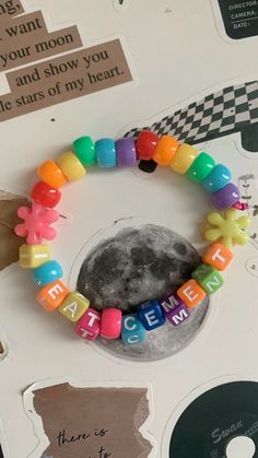 a close up of a bracelet with letters on it and a moon in the background