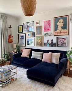 a living room filled with furniture and lots of pictures on the wall above it's couch