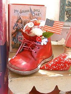 a pair of red boots sitting on top of a table next to an american flag