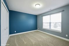 an empty room with blue walls and carpet