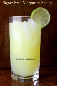 a tall glass filled with lemonade and lime juice on top of a wooden table