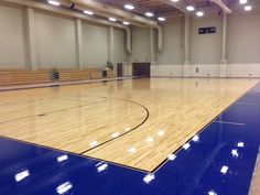 an indoor basketball court with benches and lights