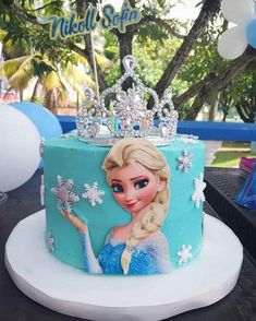 a frozen princess cake on a table with balloons