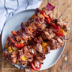 skewered meat and vegetables on a white plate