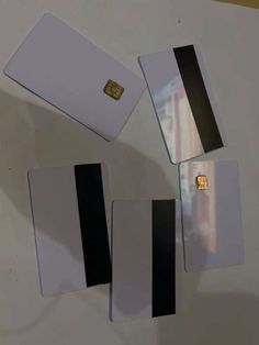 four credit cards are laying next to each other on a white surface with gold foil