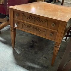 an old wooden table with carvings on it in a room filled with other antique furniture