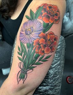 a woman's arm with flowers on it, and a bow around the wrist