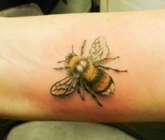 a small bee tattoo on the arm and foot is shown in black and yellow colors