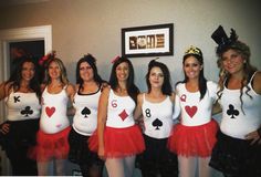 a group of women dressed in costumes posing for a photo with cards on their bodies