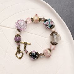 "This chunky boho bracelet features beautiful purple flowers and intricate floral details. It's the perfect addition to any bohemian-inspired outfit, adding a touch of charm and elegance. The chunky design of the bracelet makes it a statement piece that is sure to get noticed.  💕 You will definitely look stunning with this cute beaded bracelet! 👉 Please note that this bracelet has a fixed size and is designed to fit a wrist circumference of 15.5-16.5cm (6.1\"- 6.5\" inches). If you require a s Bohemian Purple Crystal Bracelet Gift, Handmade Purple Bohemian Stretch Bracelet, Bohemian Style Stretch Bracelet Gift, Bohemian Bracelets With Purple Round Beads, Bohemian Purple Beaded Bracelets For Jewelry Making, Bohemian Purple Crystal Bracelet With Round Beads, Purple Bohemian Beaded Bracelets As Gift, Handmade Purple Bohemian Beaded Bracelets, Bohemian Purple Stretch Bracelet With Round Beads