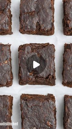 chocolate brownies are arranged in rows on a sheet of white paper with the video below them