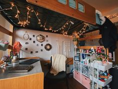 a loft bed with lights strung from the ceiling and decorations on the wall above it