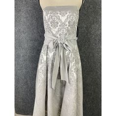 This Elegant Evening Dress From Ny & Co Is Sure To Turn Heads At Any Party Or Event. The Strapless Silhouette And Midi Length Make It A Perfect Choice For A Cocktail Or Formal Occasion. The Dress Features A Beautiful Damask Pattern In Gray-Silver, With A Zip Closure At The Back And A Satin Tie To Cinch In At The Waist. Chest: 32 Waist: 30 Length: 37 #H-Cl E&P Silver Strapless Dress With Fitted Bodice, Sleeveless Silver Evening Dress For Banquet, Silver Sleeveless Evening Dress For Banquet, Silver Sleeveless Dress For Banquet, Silver Strapless Fitted Evening Dress, Silver Fitted Strapless Evening Dress, Sleeveless Silver Satin Evening Dress, Silver Sleeveless Satin Evening Dress, Silver Satin Sleeveless Evening Dress