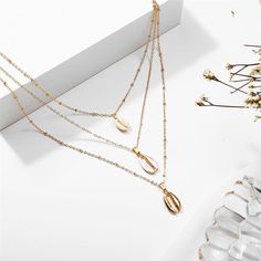 Bring sea-inspired shine to your everyday accessorizing with this gleaming 18k gold-plated necklace flaunting three chains and iridescent shell pendants for layers of beachy bling. Chain 1 : 16.54" L with 1.96" extender Pendant 1 : 0.24" W x 0.67" L Chain 2 : 21.26" L with 2.36" extender Chain 3 : 26.77" L with 2.36" extender Pendant 2 & 3: 0.31" W x 0.75" L Lobster claw clasp 18k gold-plated copper / shell Iridescent Shell, Sea Inspired, Shell Pendant, Shell Necklaces, Gold Plated Necklace, Collar Necklace, Statement Jewelry, Layered Necklaces, Arrow Necklace