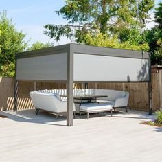 a white couch sitting on top of a wooden deck next to a table and chairs