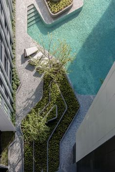 an aerial view of a building with a pool in the foreground and stairs leading up to it