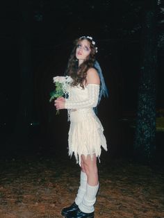 a woman in a white dress holding flowers