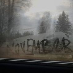 the word lovecraft written in black ink on a window sill with trees behind it