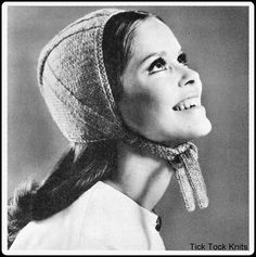 a black and white photo of a woman wearing a knitted hat with long hair