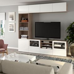 a living room with furniture and a large flat screen tv mounted on the wall above it