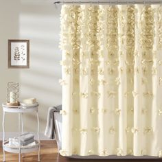 a shower curtain with white flowers on it in a bathroom next to a bathtub