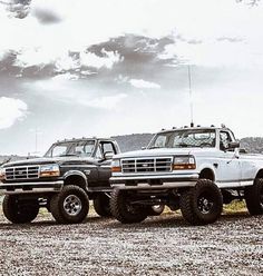 two trucks are parked in the middle of a field