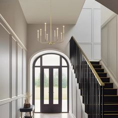 an entryway with stairs and chandelier in the middle, leading to a foyer