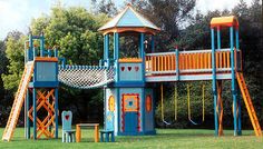 a play set in the middle of a grassy area with trees and bushes behind it