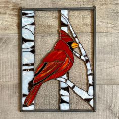 a stained glass cardinal perched on a branch