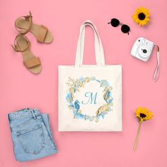 a personalized tote bag with sunflowers, sunglasses and other items on a pink background