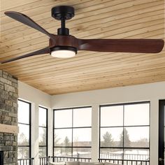 a ceiling fan in a living room with large windows