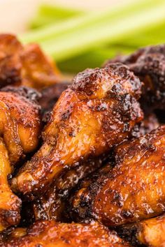 chicken wings covered in bbq sauce with celery on the side, close up