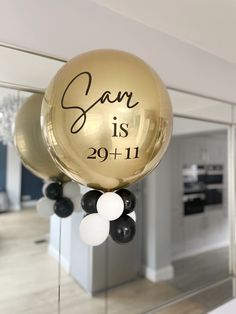 some balloons that say san is 29 + 11 and are hanging from the ceiling in front of a mirror