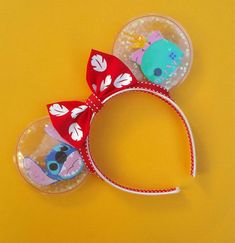 two mickey mouse ears with red bows on top of each other and an animal headband around the ears