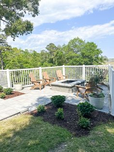 a patio with chairs and a hot tub on the back deck, surrounded by trees