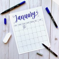 a calendar with the word january written on it next to some markers and pencils