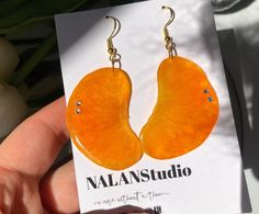 Tangerine earring **Materials: - Real hand pressed fruit - Swarovski Crystals - Hypoallergenic nickel-free 925 sterling silver - Jewelry grade resin from USA **Size: 2-2.5in  They are carefully sliced, dried and preserved in an eco-friendly resin. Each one has its own size, shape and imperfection, so the pair you see pictured will not be the pair you receive but they will be very similar! That means that when you buy a pair of fruit earrings, nobody else in the world will have one just like yours! **Because the earrings are made with real fruit, you may find natural flaws in the fruit or inside the resin such as tiny air bubbles, seeds or natural nature stuff :) Each slice will vary in size since they are all hand sliced! **They were made with love so please treat them with love.  Fading o Botanical Earrings, Real Fruit, West Covina, Food Earrings, Fruit Earrings, Natural Nature, Earring Gift, Air Bubbles, Bridesmaid Gift