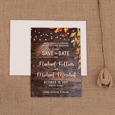 a wedding save - the - date card on top of a piece of wood