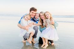 a family poses for a photo on the beach