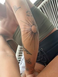 the woman is showing off her tattoos on her arm