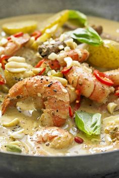 a bowl filled with shrimp and vegetables on top of a table